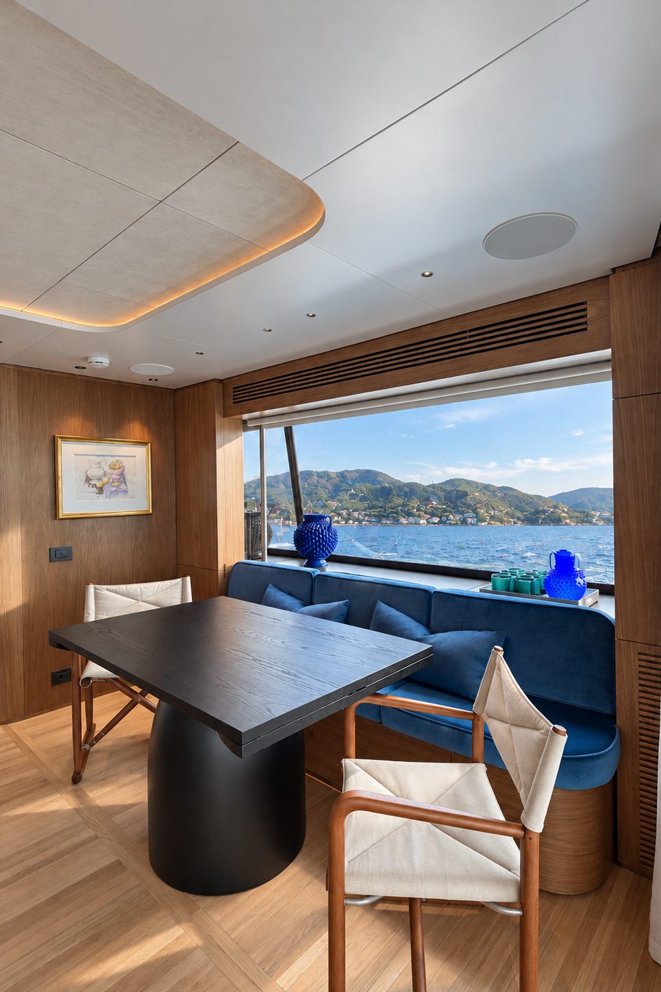 Dining corner with a black table, director's chairs and a blue sofa by the window