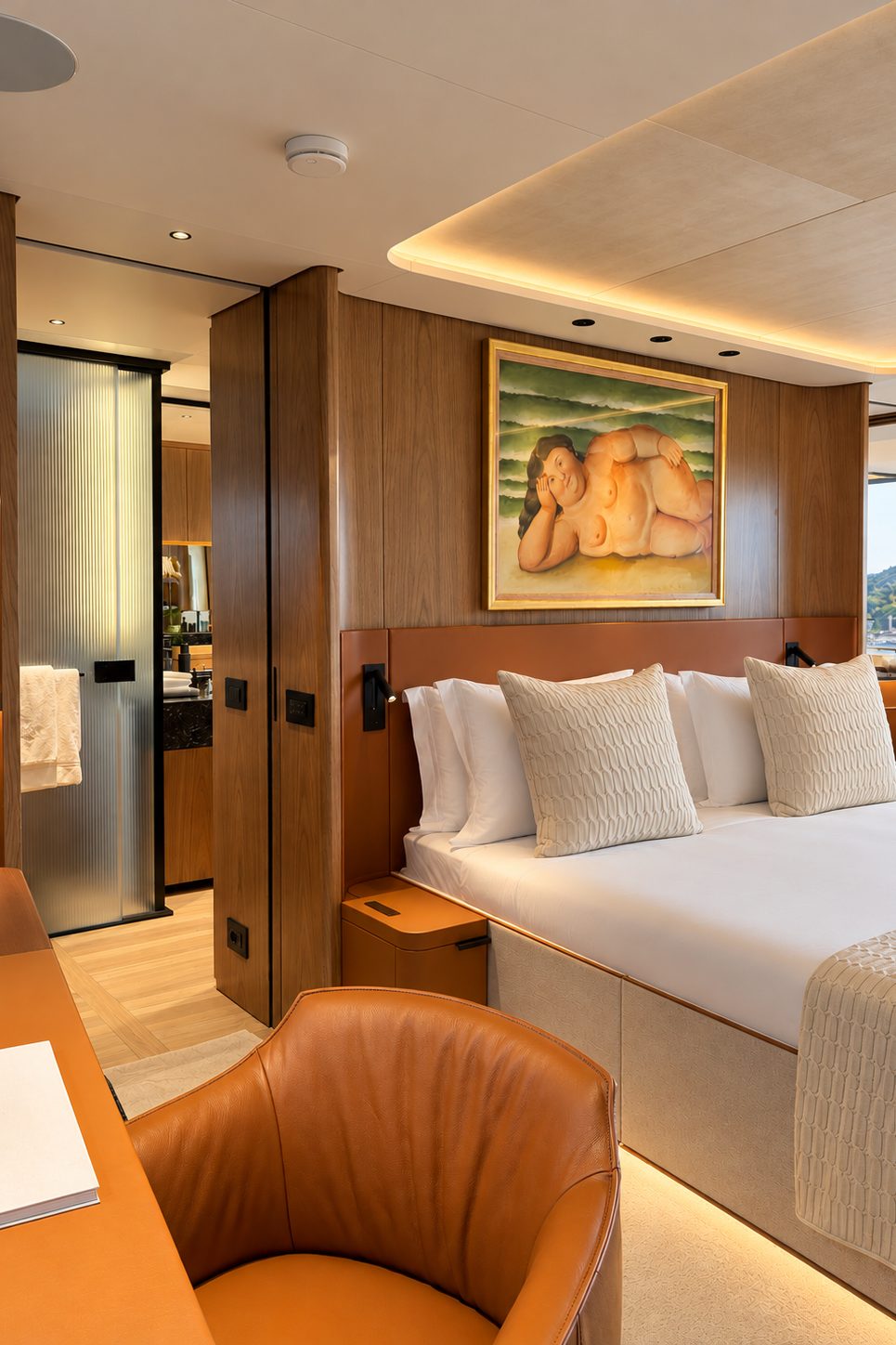 Guest cabin with a leather armchair, a desk and a framed painting above the bed